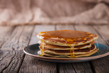 Pancake folded stack of with liquid honey on wooden background.selective focus.