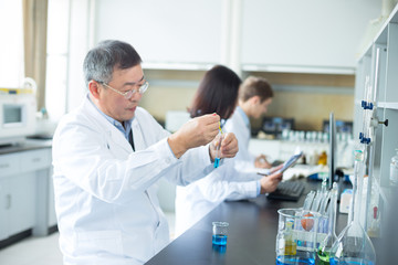 Fototapeta premium people doing chemical experiment in modern lab