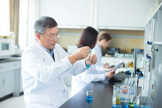 People Doing Chemical Experiment In Modern Lab