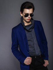 Obraz premium Vogue handsome man in the jacket and sunglasses in the studio