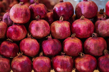 Pomegranate slices and garnet fruit seeds on table. Selective focus.