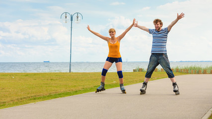 Young couple on roller skates riding outdoors