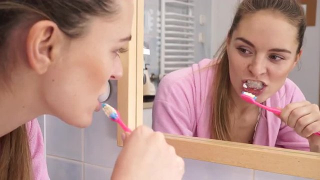 Woman brushing cleaning teeth in bathroom 4K