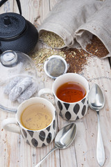 two cups 1 black tea rooibos and other fennel with teapot in the