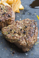 Grilled T-bone steak seasoned with spices and fresh herbs served