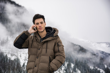 Young man in at mountain using cell phone