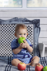 Baby boy in parent's bed with paraffin wax apple