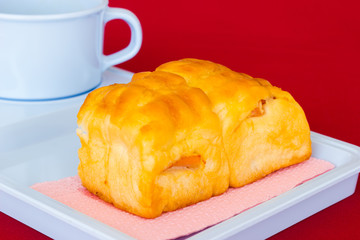 bread and white tea cup on red table