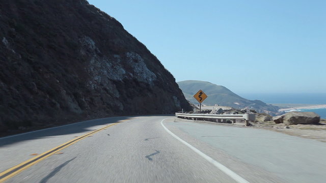 View of driving on Pacific Coast Highway (aka Highway 1) on the Central California coastline in the Point Sur area of Big Sur. 