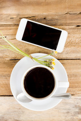 coffee cup and smart phone on wood table. modern office desktop