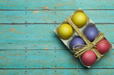 Colorful Easter Eggs with a Twine Bow on a Wood Background