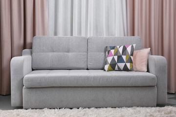 Grey sofa against curtains in the room