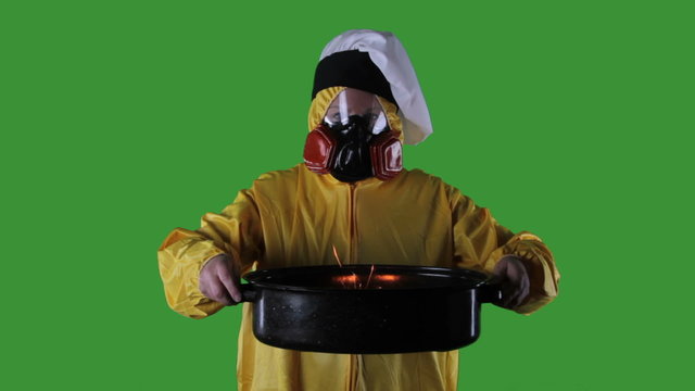 Woman wearing HazMat suit with Chefs hat holding buring roasting pan,