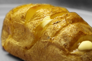 Baked potato / Baked potato with melting butter on a plate.