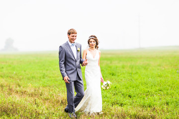 Young wedding couple walking outdoors