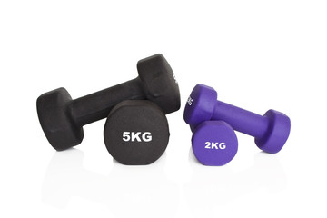 Fitness dumbbells. Black 5 kg and purple 2 kg dumbbells isolated on white background. Weights for a fitness training.