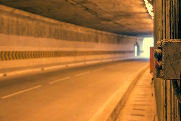 Switch on highway road tunnel with light coming from the exit