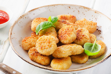 Crispy chicken nuggets with sauce.