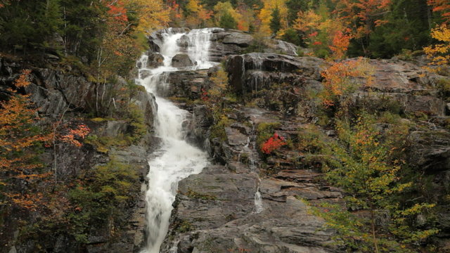 Locked down portion followed by a tilt down of Silver Cascade waterfall during Autumn, in Crawford Notch State Park, in the white mountains of New Hampshire; includes ambient audio.