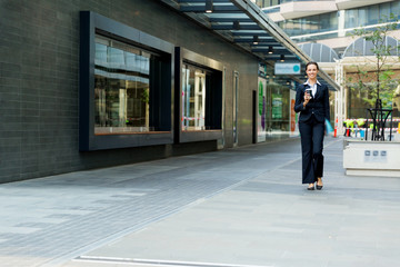 Portrait of business woman walking and smiling outdoor