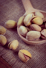 Vintage photo, Pistachio nuts with spoon on wooden table, healthy eating