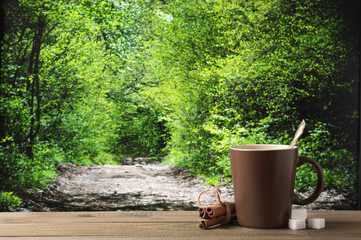 Coffee cup against forest landscape