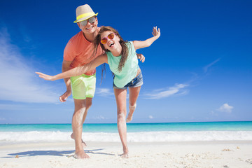 romantic couple in bright clothes enjoying sunny day at tropical beach