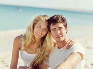 Fototapeta na wymiar Romantic young couple sitting on the beach