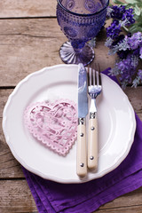 Summer table setting. Blue  and violet flowers,  pink heart, kni