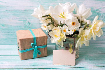 Narcissus flowers , empty tag for text , box with present  on tu