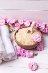 Obraz na płótnie Canvas Organic sea salt in bowl with towels and pink flowers