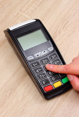 Hand of woman using payment terminal, enter personal identification number