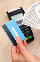 Currencies dollar with credit card and payment terminal in background, finance concept