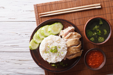 Hainanese chicken rice, chilli sauce and bouillon. Horizontal top view 
