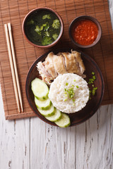 Hainanese chicken rice, chilli sauce and bouillon. vertical top view 
