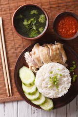Hainanese chicken rice, chilli sauce and bouillon close-up. vertical top view 
