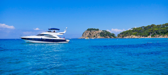 Fototapeta na wymiar Luxury yacht anchoring at steep coast