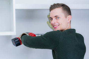 junger mann bringt regale an