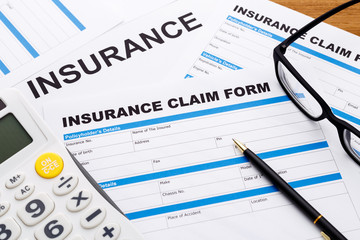 Insurance claim concept with pen and calculator