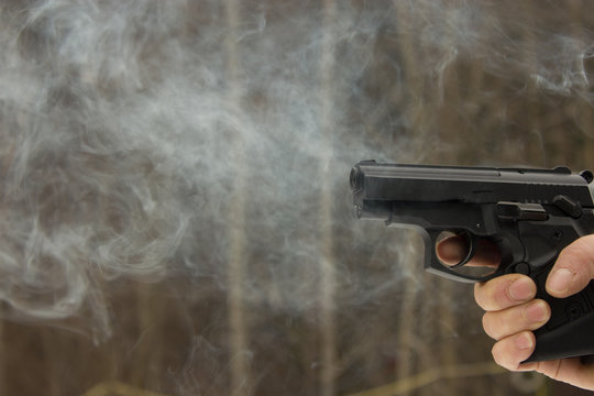 Frau sch&uuml;tzt sich mit Pistole, bereit zur Selbstverteidigung.