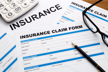 Insurance claim form with pen and calculator