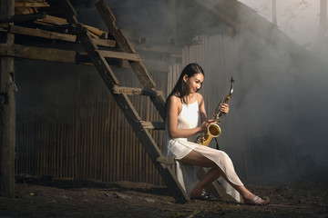 beautiful girl play music on saxophone