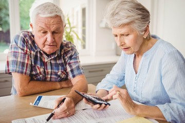 Worried senior couple checking their bills - Powered by Adobe