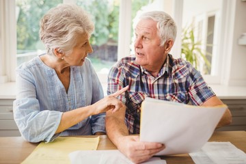 Worried senior couple checking their bills