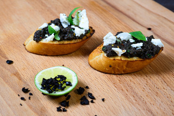 bruschetta Tapenade, with olives on old wooden Board