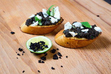 bruschetta Tapenade, with olives on old wooden Board