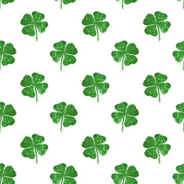 Seamless pattern of abstract four-leaf clovers of green glitter