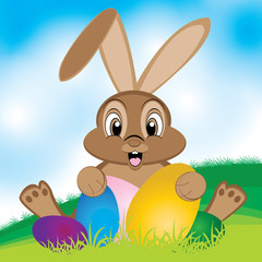 Easter bunny with colorful egg. Little gift at Easter. Easter eggs on the meadow And a beautiful sky.