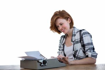 smiling hipster woman typing on her typewriter