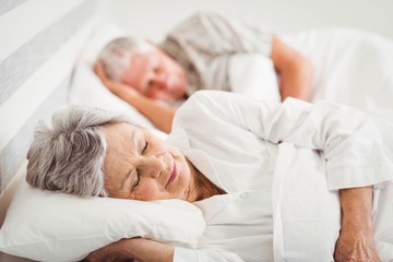 Senior couple sleeping on bed - Powered by Adobe